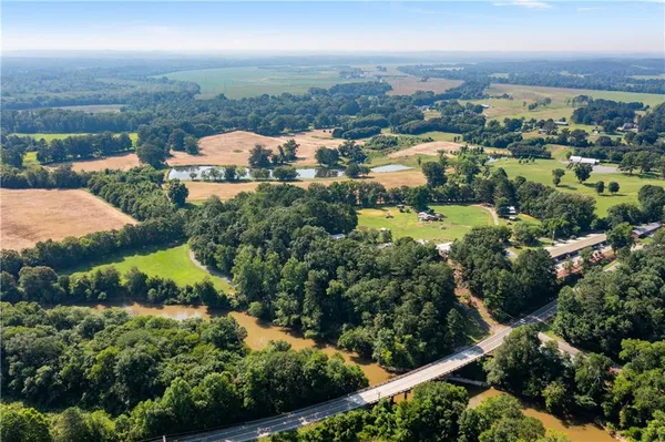 an aerial view of residential houses with outdoor space and trees
