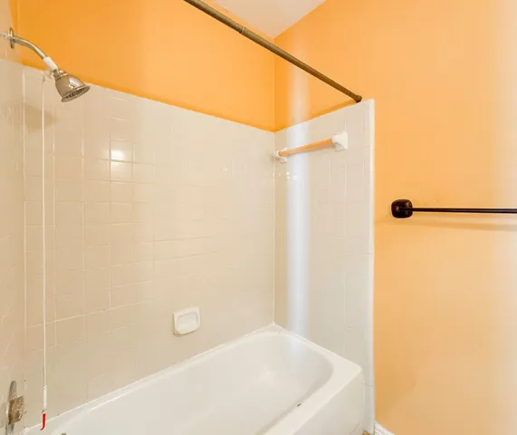 a bathroom with a white bath tub and shower