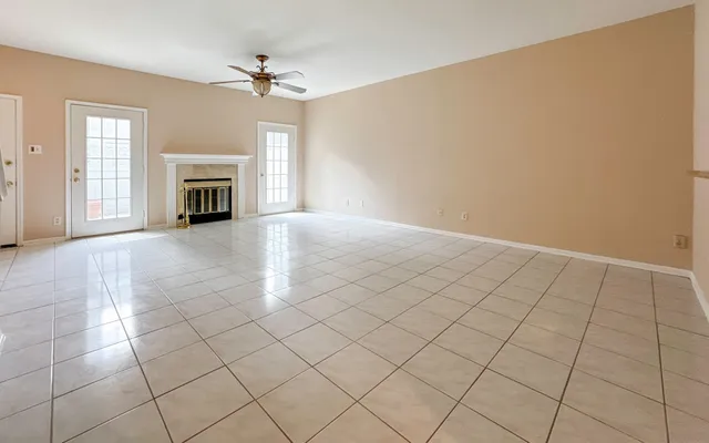 an empty room with fireplace and windows