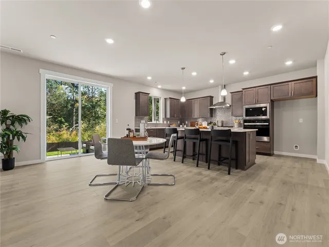 a kitchen with stainless steel appliances granite countertop a refrigerator and a stove top oven with wooden floor