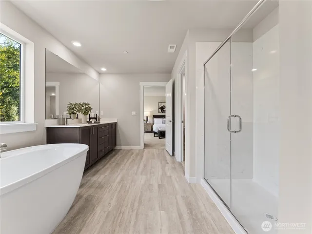 a bathroom with a tub sink mirror and window
