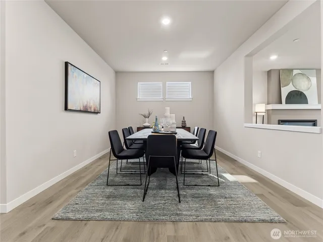 a dining room with wooden floor and a rug