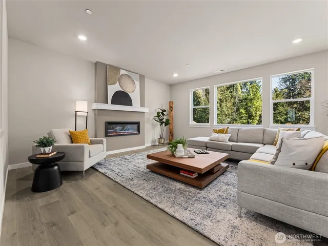 a living room with furniture fireplace and a large window