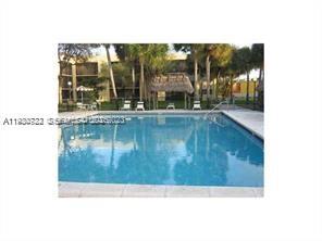 8075 Southwest 107th Avenue, Unit 210 Miami, FL 33173 - Photo 19 of 33 a swimming pool with outdoor seating and garden