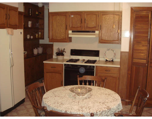 77 Sunapee Street Springfield, MA 01108 - Photo 12 of 28 a kitchen with a stove a refrigerator a sink a stove and wooden cabinets