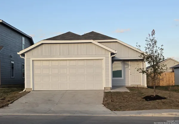 a view of a white house with a yard and garage