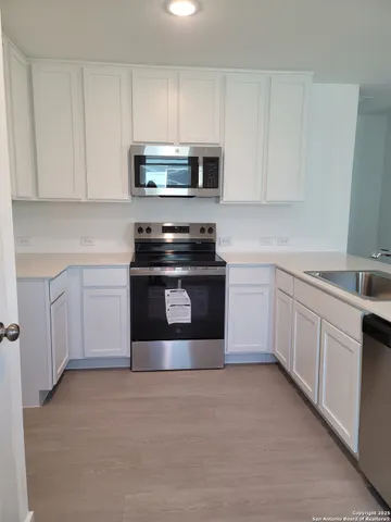 a kitchen with white cabinets and stainless steel appliances