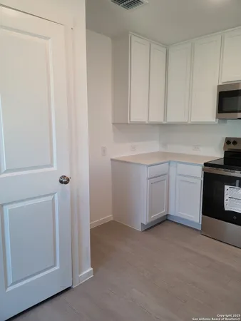 a kitchen with a cabinets and white appliances
