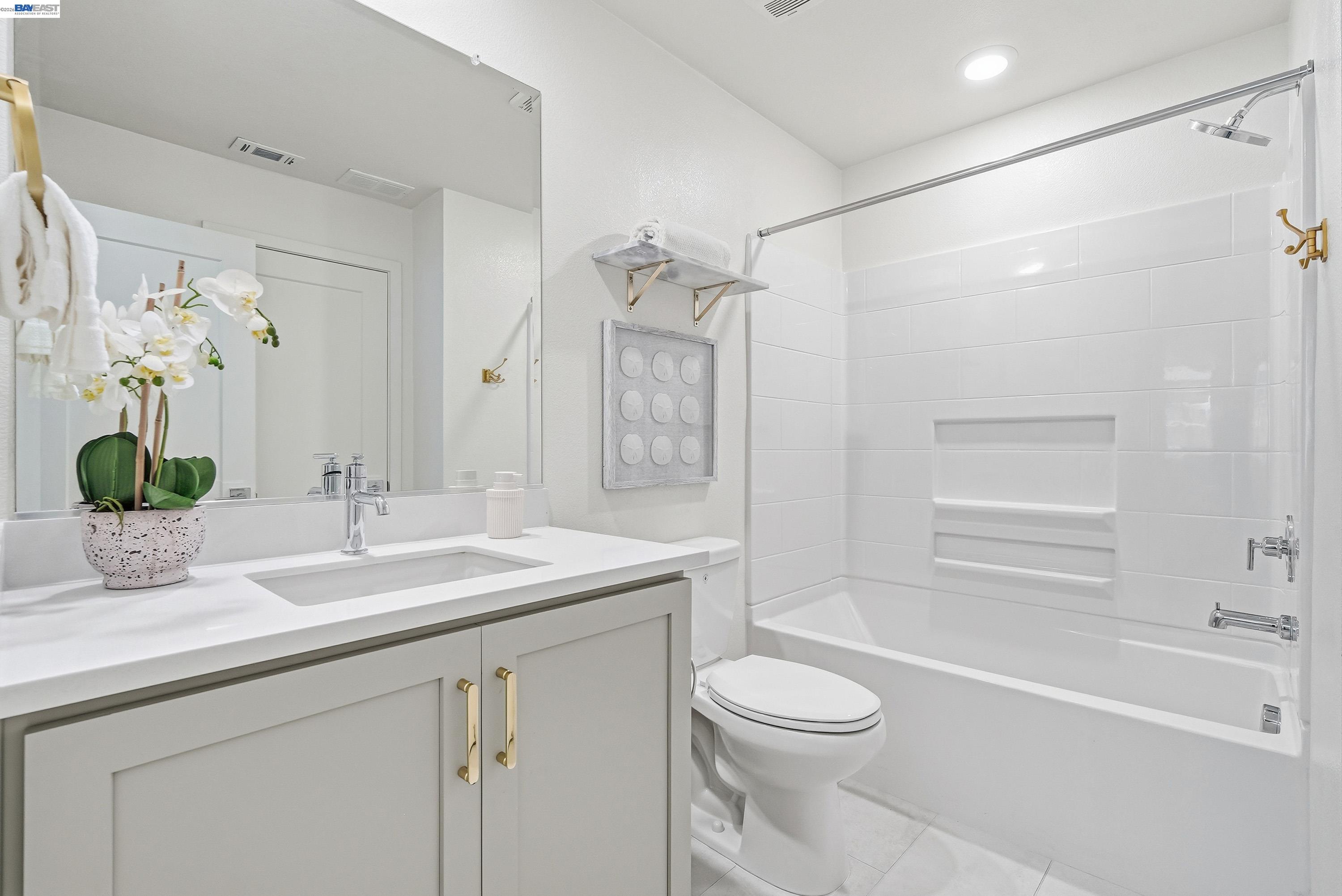 9620 Seawind Way Newark, CA 94560 - Photo 18 of 55 a bathroom with a granite countertop sink a toilet a mirror a vanity a shower and bathtub