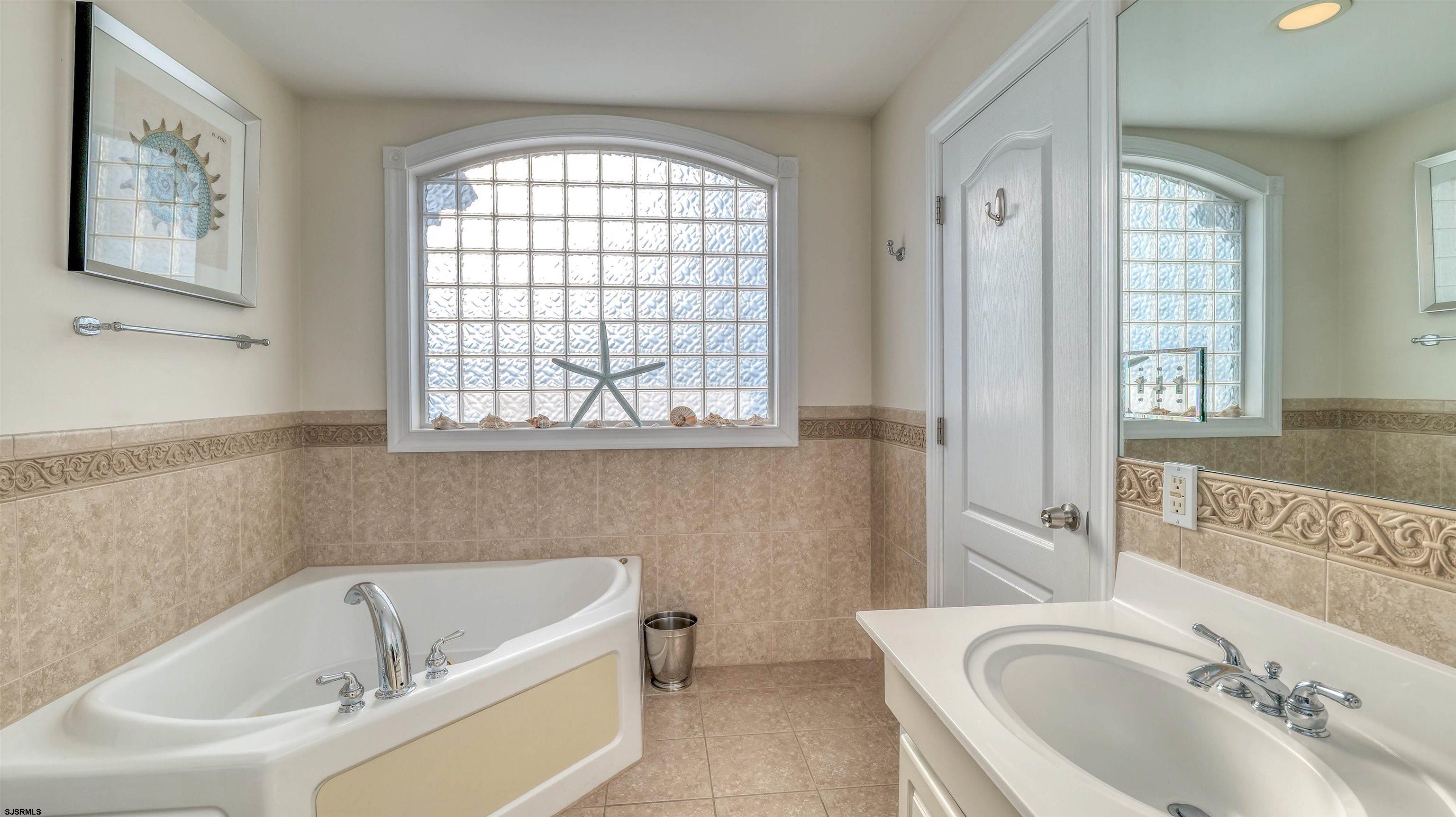 119 North Belmont Avenue, Unit AUGUST LABOR DAY Margate City, NJ 08402 - Photo 20 of 35 a bathroom with a tub sink and mirror