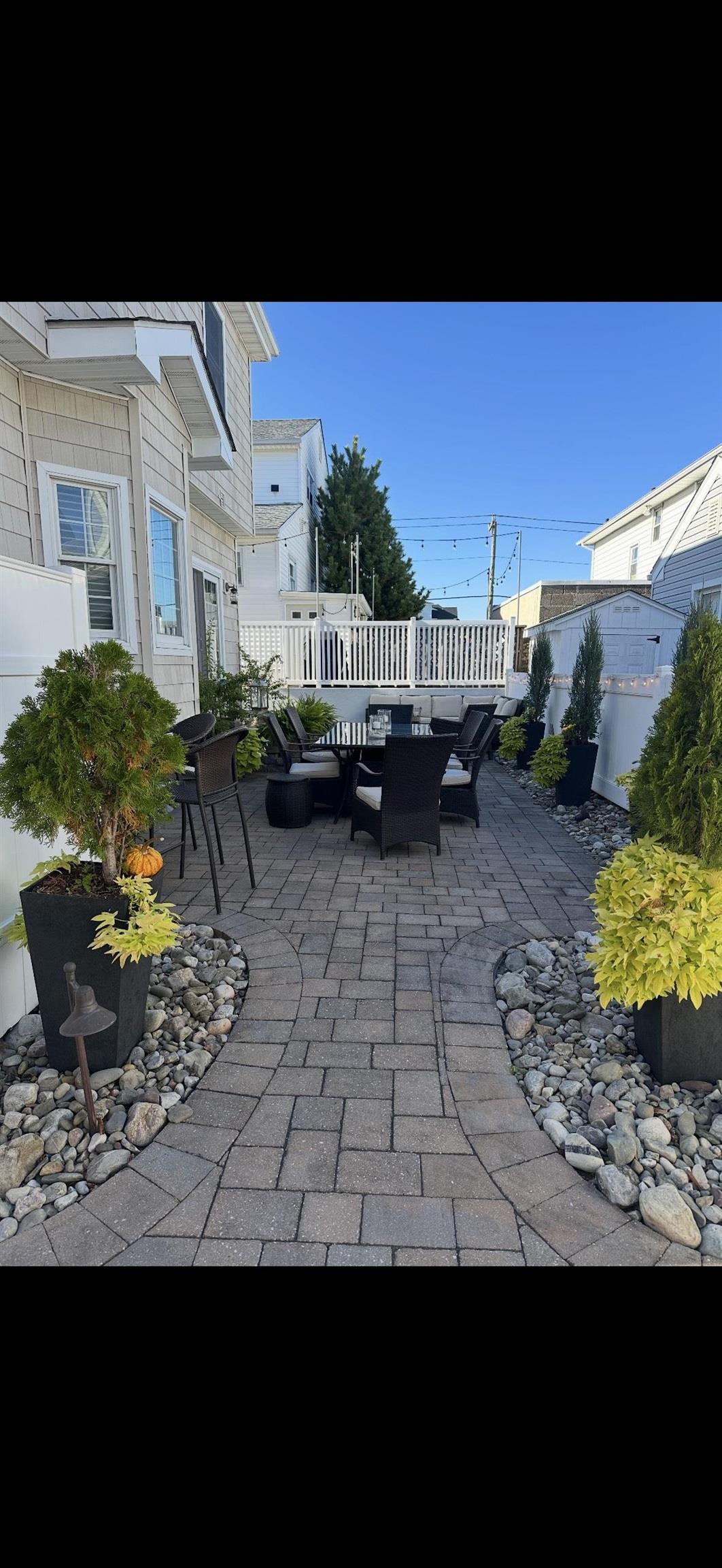 119 North Belmont Avenue, Unit AUGUST LABOR DAY Margate City, NJ 08402 - Photo 31 of 35 a view of a backyard with table and chairs couches under an umbrella