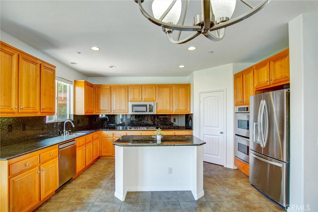 9350 Dauchy Avenue Riverside, CA 92508 - Photo 9 of 34 Chef’s Kitchen Perfection! Featuring expansive granite countertops, a central prep island, and high-end stainless steel appliances including double ovens—this space is designed for effortless entertaining and large family gatherings.