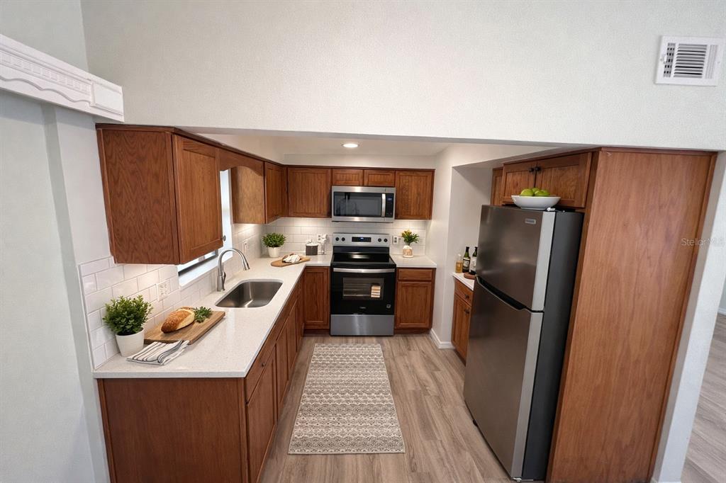 3823 Pine Ridge Road Orlando, FL 32808 - Photo 2 of 13 a kitchen with granite countertop a refrigerator stove and oven