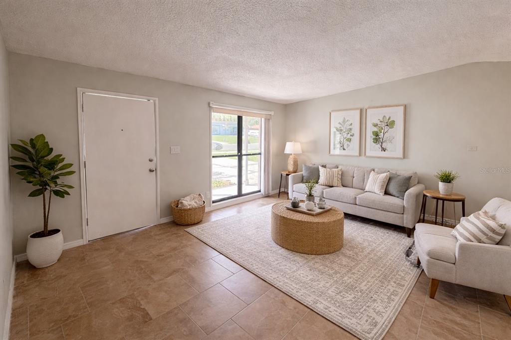 3823 Pine Ridge Road Orlando, FL 32808 - Photo 4 of 13 a living room with furniture and a window