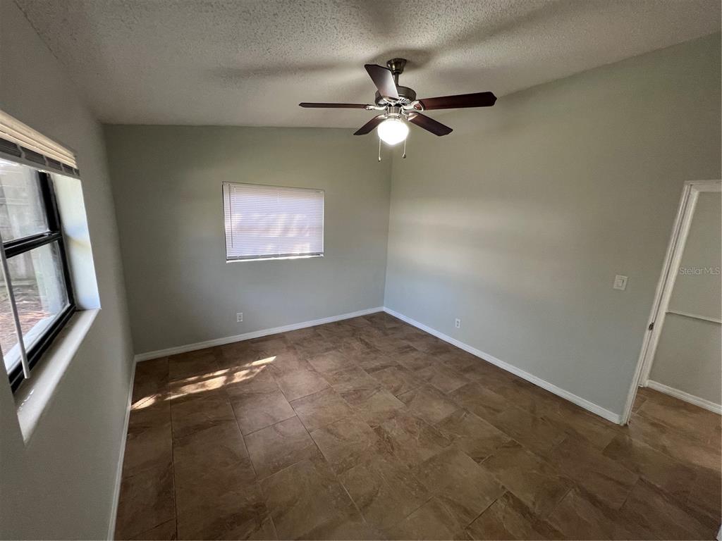3823 Pine Ridge Road Orlando, FL 32808 - Photo 9 of 13 an empty room with windows and fan