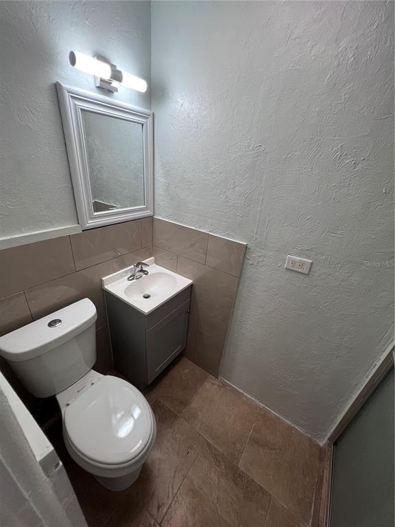 3823 Pine Ridge Road Orlando, FL 32808 - Photo 10 of 13 a bathroom with a toilet sink and mirror