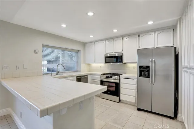a kitchen with stainless steel appliances a refrigerator sink and stove