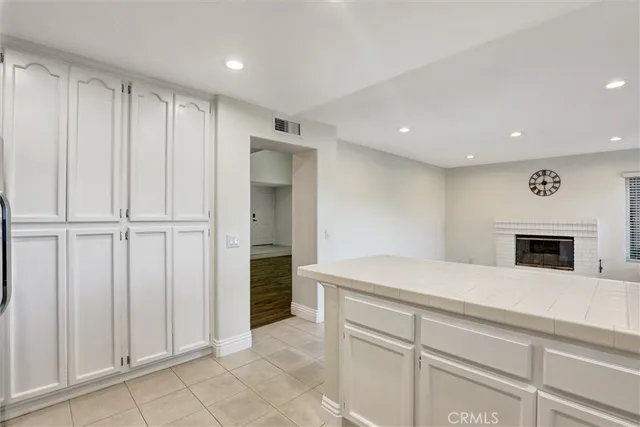 a kitchen with a refrigerator and white cabinets