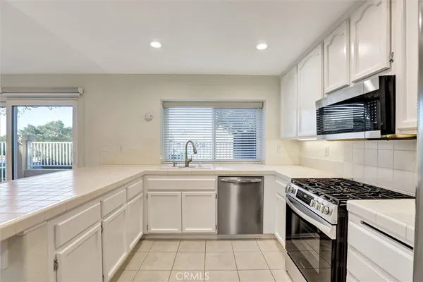 a kitchen with a sink stove top oven and cabinets