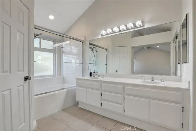 a bathroom with a double vanity sink mirror and bathtub
