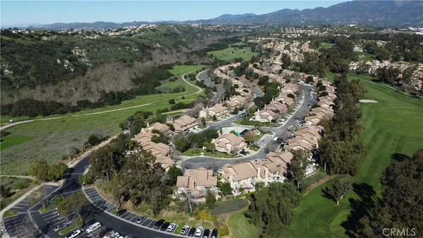 an aerial view of a residential houses with outdoor space and trees