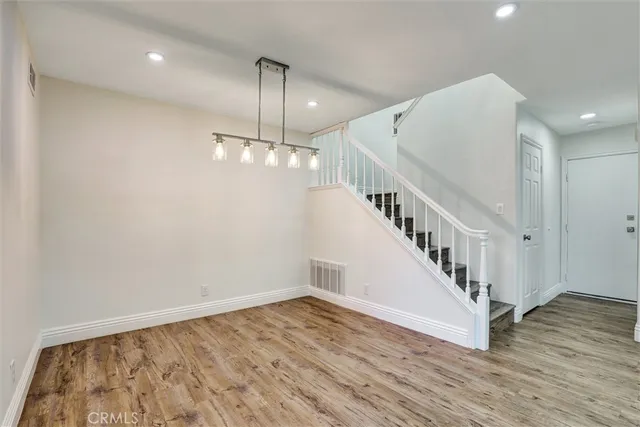 a view of staircase with white walls and wooden floor