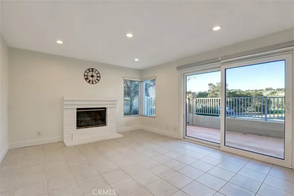 a view of empty room with floor to ceiling window and fireplace