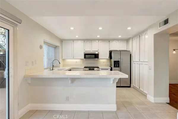 a kitchen with stainless steel appliances a sink stove and refrigerator