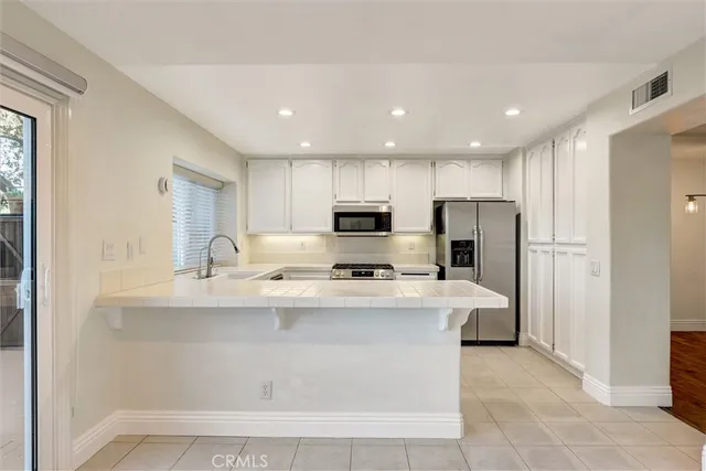 a kitchen with stainless steel appliances a sink stove and refrigerator