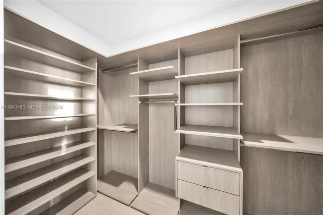 a view of walk in closet with empty racks