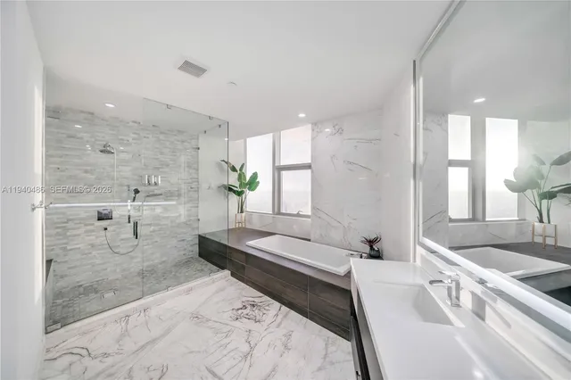 a spacious bathroom with a double vanity sink a large mirror and shower