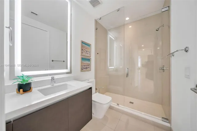 a bathroom with a bathtub shower sink mirror and toilet