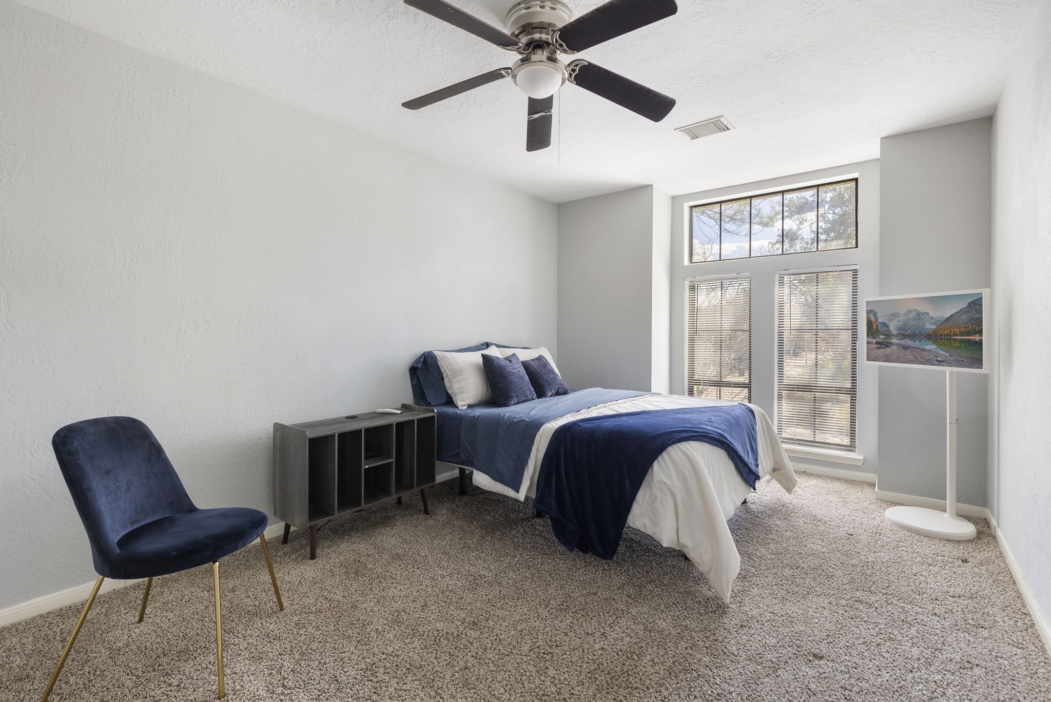 2110 Paso Rello Drive Houston, TX 77077 - Photo 33 of 41 Cozy secondary bedroom with neutral walls and carpet, featuring a ceiling fan and large windows for natural light.