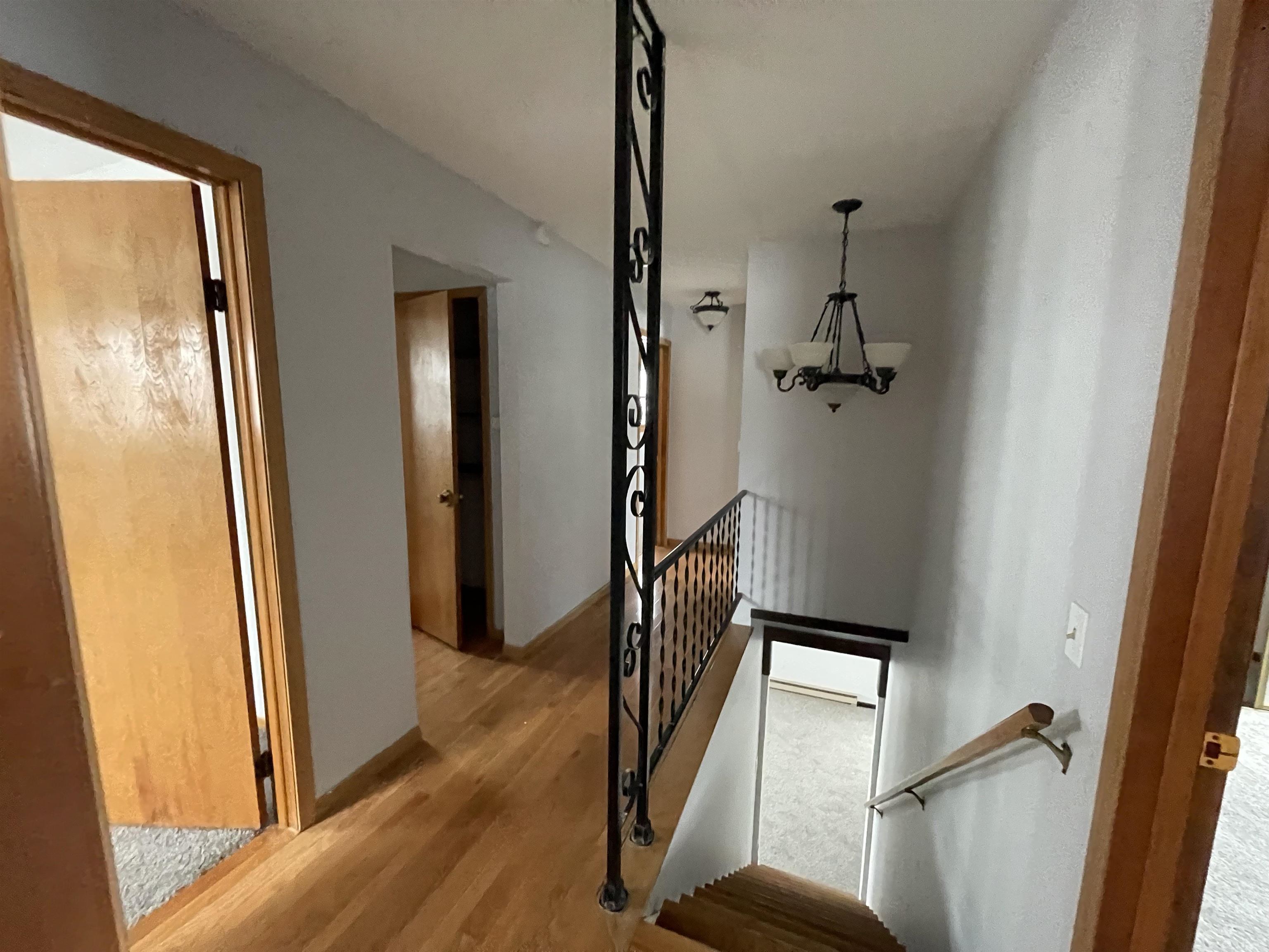 7870 Freeport Road Rockton, IL 61072 - Photo 13 of 22 a view of a hallway with wooden floor and staircase