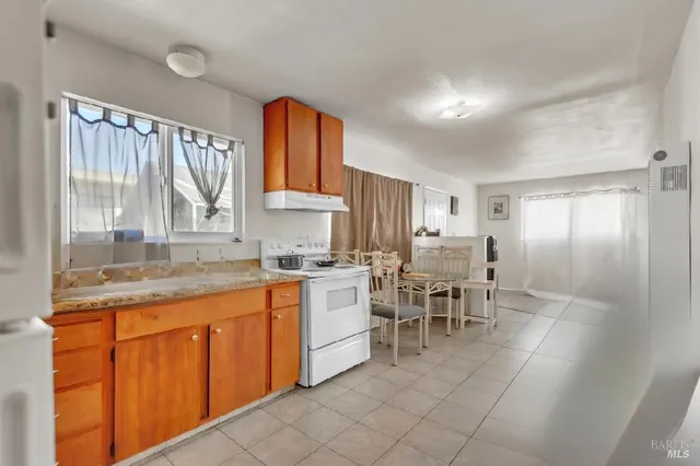 a large kitchen with kitchen island a sink and a large window