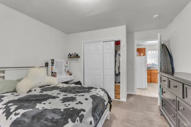 a bedroom with a bed and a refrigerator