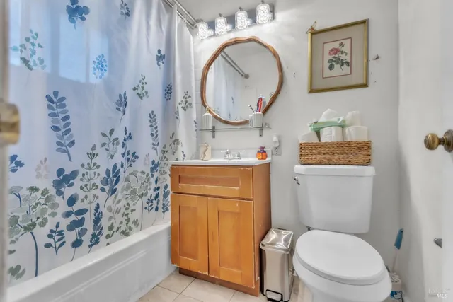a bathroom with a granite countertop toilet sink and mirror