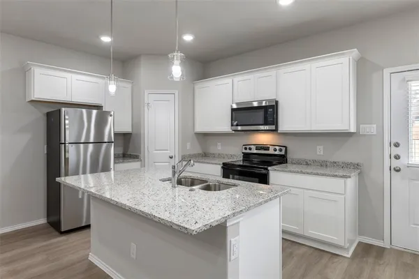 a kitchen with stainless steel appliances granite countertop a sink stove and refrigerator