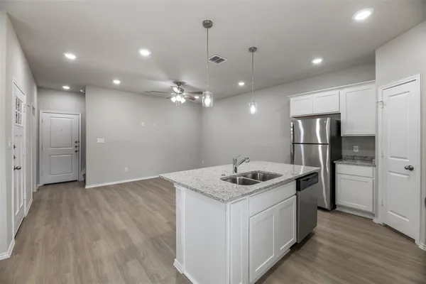 a kitchen with a sink chandelier and refrigerator