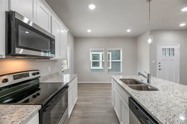 a kitchen with a stove sink and microwave