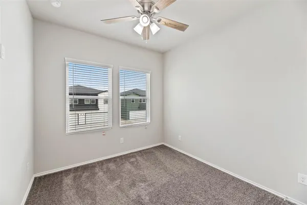 an empty room with a window and a fan