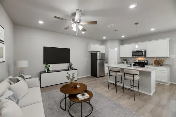 a living room with furniture kitchen view and a flat screen tv