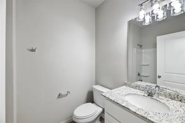 a bathroom with a granite countertop sink a toilet and a mirror