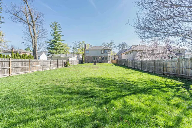 a view of a backyard with a garden and tree