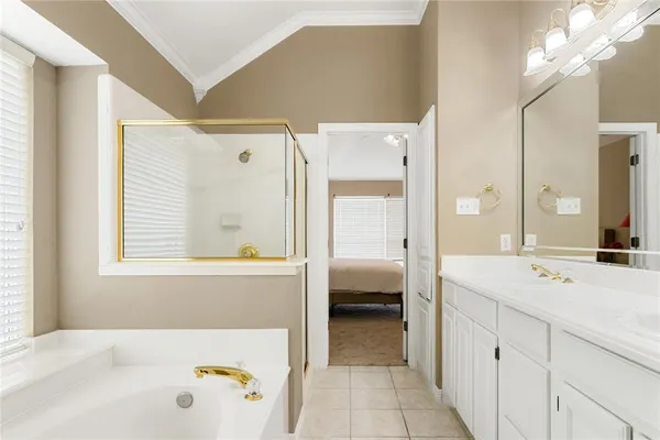 a en suite bathroom with a tub sink and mirror