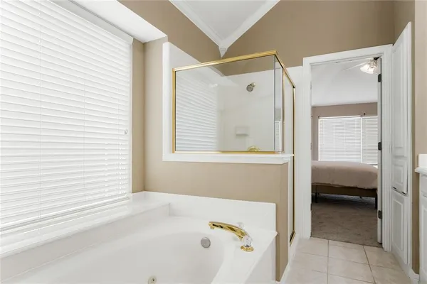 a en suite bathroom with a tub shower and mirror