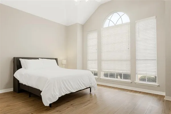 a bedroom with a bed and a large window