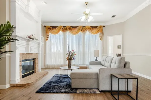 a living room with furniture a fireplace and a floor to ceiling window