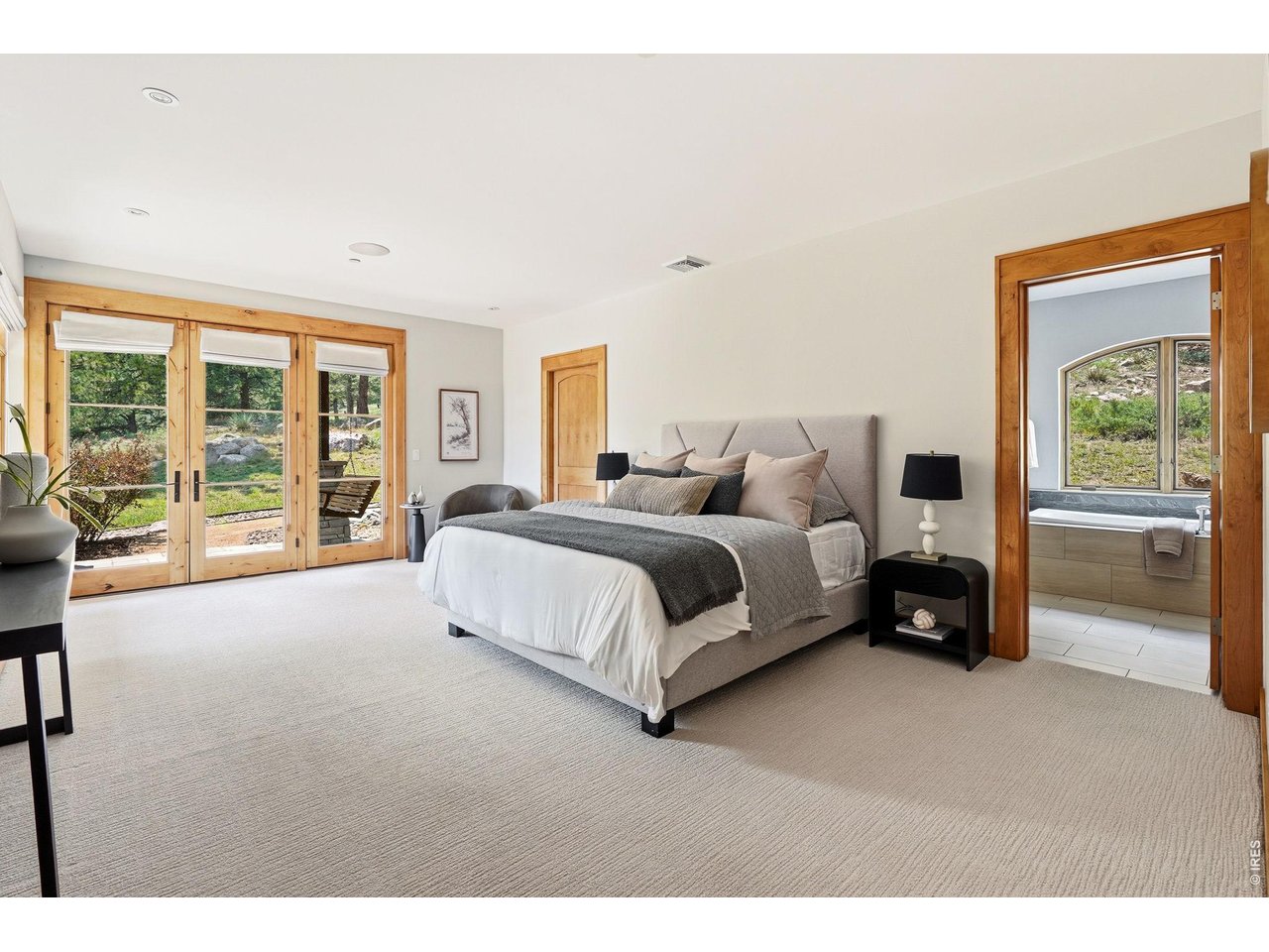 575 Reed Ranch Road Boulder, CO 80302 - Photo 20 of 47 a spacious bedroom with a bed a table and a large mirror
