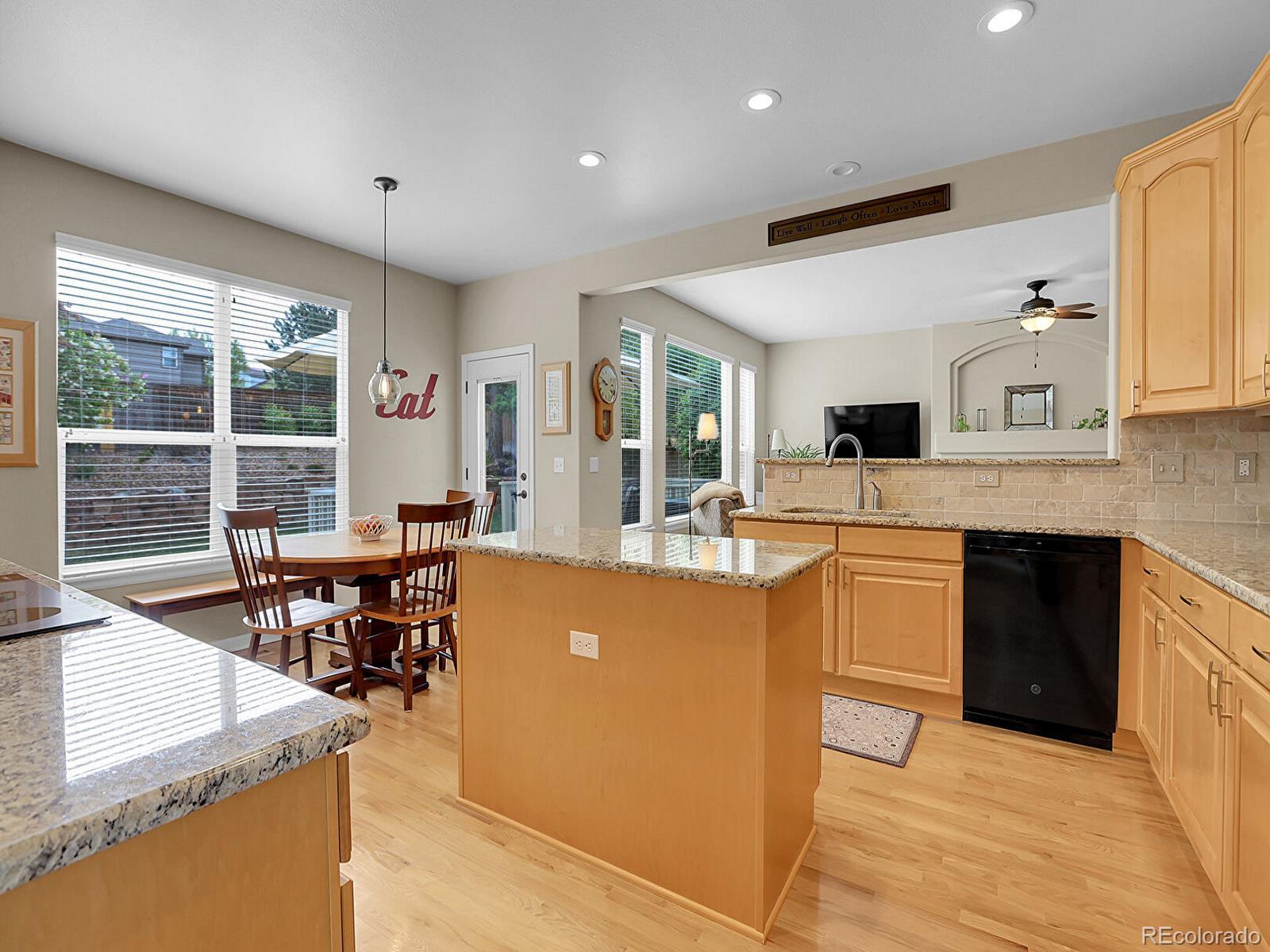 7138 Mountain Brush Circle Highlands Ranch, CO 80130 - Photo 11 of 50 a large kitchen with kitchen island a sink and a stove top oven